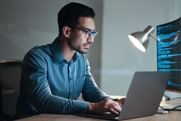 Laptop, screen and business man for coding, software development and programming script in cybersecurity. Night, computer research and programmer or IT person with html code, system or data analysis.